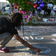 People leave messages at a makeshift memorial near a Tops Grocery store in Buffalo, New York, on May 15, 2022, the day after a gunman shot dead ten people.